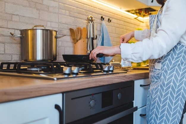 Mujer freír en pan cocina vista