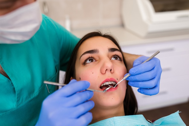 Mujer con frenillos, dientes en el consultorio dental.