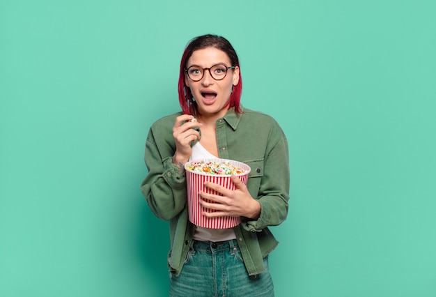 Mujer fresca de pelo rojo con palomitas de maíz