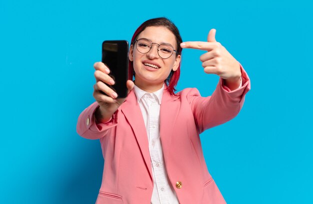 Mujer fresca de pelo rojo con un teléfono inteligente