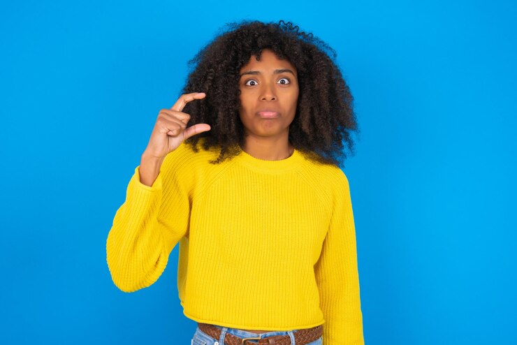 Foto la mujer frunce el labio y los gestos con la mano muestran algo muy pequeño