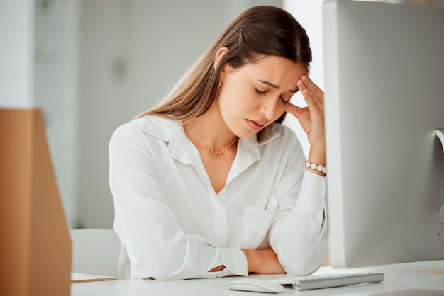 Mujer frustrada dolor de cabeza y estrés con dolor en ansiedad depresión o exceso de trabajo en la oficina Mujer joven o empleada con migraña tensión o presión por fatiga vértigo o mareos