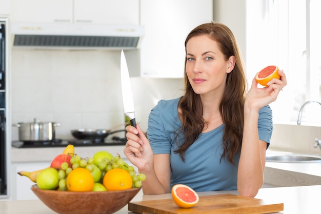 Mujer con frutero en mostrador en cocina