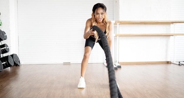Una mujer fuerte que entrena en un club de fitness utiliza equipos deportivos Gimnasia y aeróbic