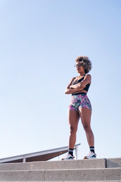 Mujer fuerte con ropa deportiva de pie al aire libre