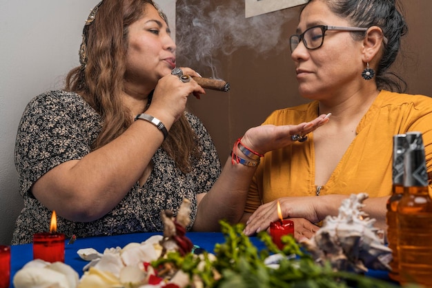 Mujer fumando un puro y soplando el humo en la cara de otra mujer