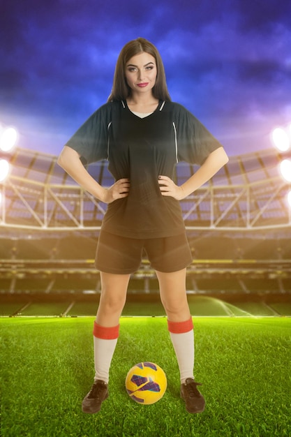 Foto mujer futbolista con balón de fútbol en el estadio