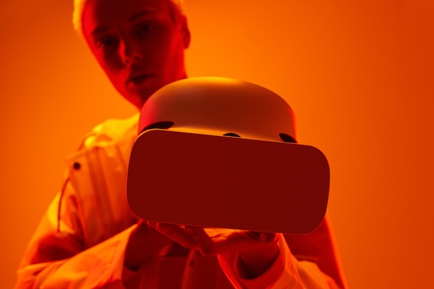 Mujer futurista mostrando un auricular de realidad virtual