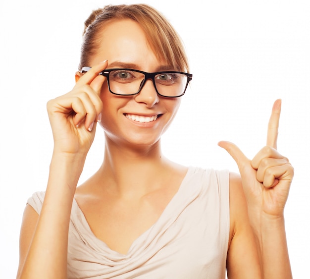 Foto mujer con gafas apuntando hacia arriba