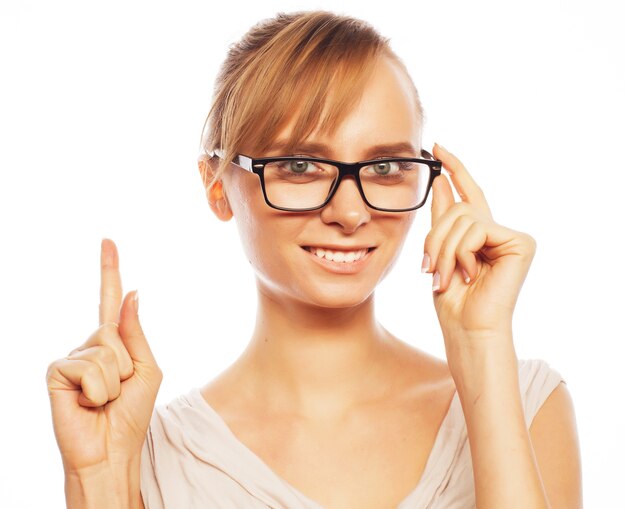 Mujer con gafas apuntando hacia arriba