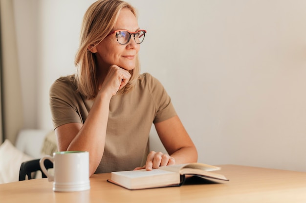 Mujer con gafas en casa leyendo durante la cuarentena