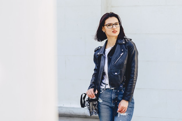 Mujer en gafas en chaqueta de cuero en la calle