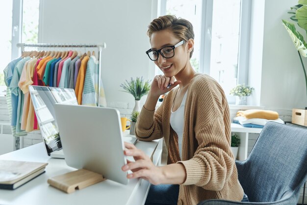 una mujer con gafas está mirando una computadora portátil