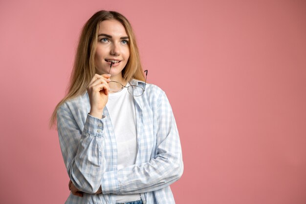 mujer con gafas en mano aislado en rosa