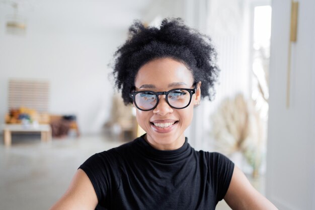 Una mujer con gafas mira a la cámara.