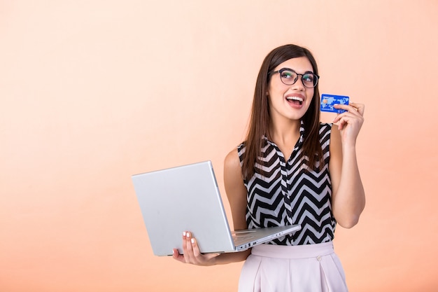 Mujer con gafas con ordenador portátil y tarjeta de crédito