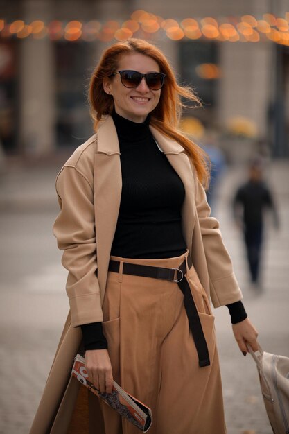 una mujer con gafas oscuras cruza la calle en un paso de peatones. mujer en la ciudad