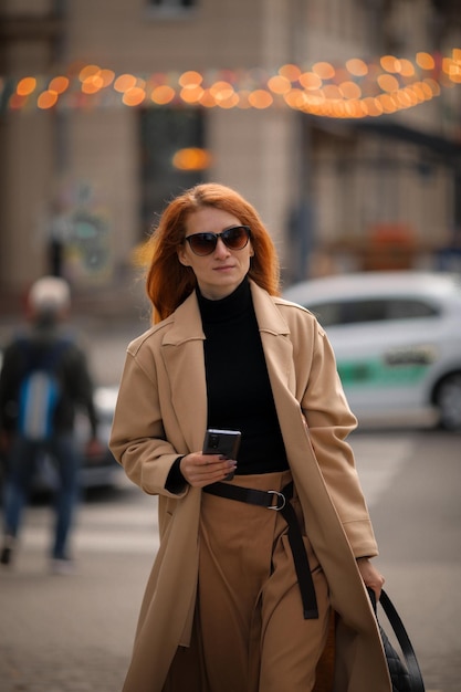 una mujer con gafas oscuras cruza la calle en un paso de peatones. mujer en la ciudad