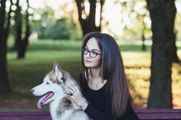 Mujer de gafas con perro husky