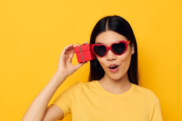 Mujer con gafas posando sobre fondo amarillo