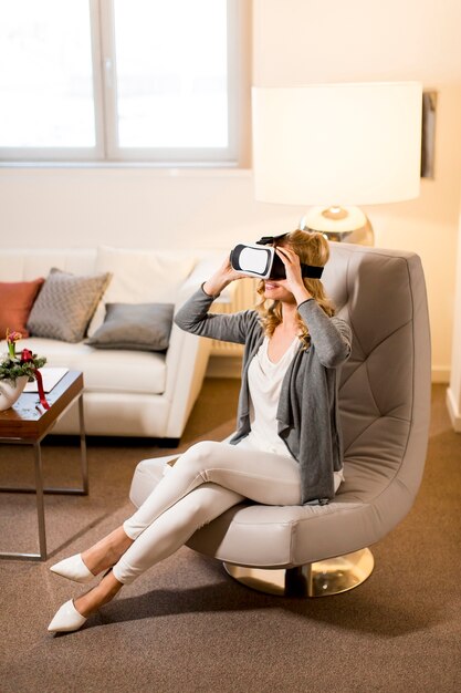 Mujer con gafas de realidad virtual en la habitación