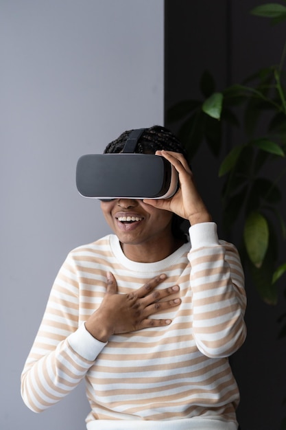 Mujer con gafas de realidad virtual se ríe con la simulación de realidad virtual probando equipos de juego en casa