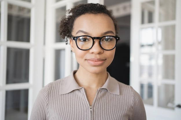 Una mujer con gafas retrato sonriendo mirando a la cámara trabajando en la oficina