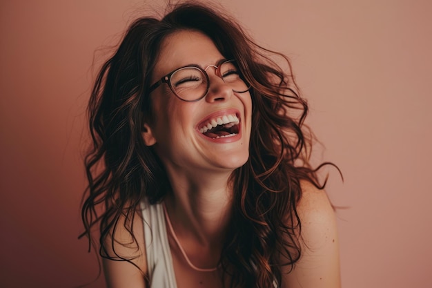 Una mujer con gafas riendo y sonriendo.