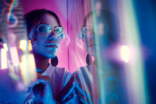 Foto mujer con gafas de sol en una habitación iluminada