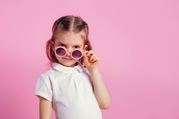 mujer en gafas de sol redondas rosas aisladas en rosa