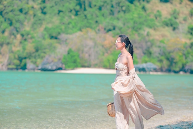 La mujer con gafas de sol se relaja en la playa de arena