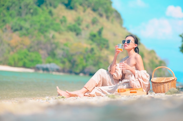 La mujer con gafas de sol se relaja en la playa de arena