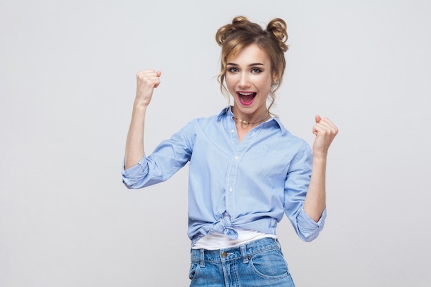 La mujer ganadora se siente afortunada mirando a la cámara, emoción y alegría sonriendo alegremente