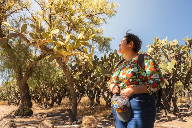 Mujer gay sonriendo al atardecer rodeada de nopales