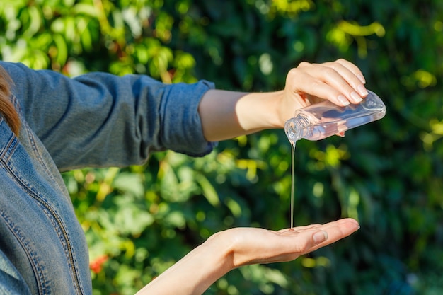 Mujer con gel antibacteriano en la naturaleza