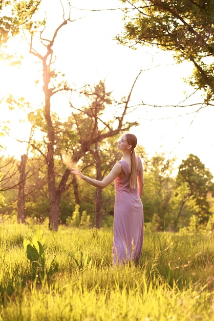 Una mujer gentil al atardecer en la naturaleza luz fabulosa