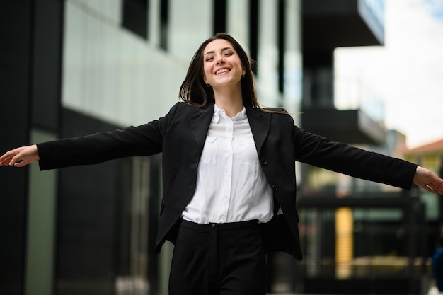 Foto mujer gerente feliz con los brazos abiertos en señal de libertad y éxito