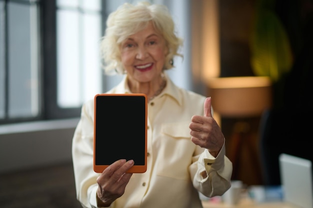 Mujer gesticulando bien mostrando la pantalla de la tableta