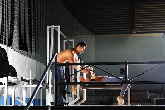 mujer en el gimnasio haciendo ejercicio con un entrenador personal