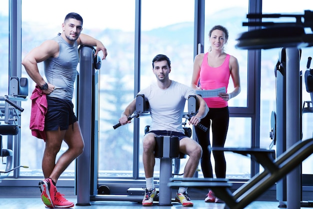 Mujer de gimnasio haciendo ejercicio con su entrenador personal