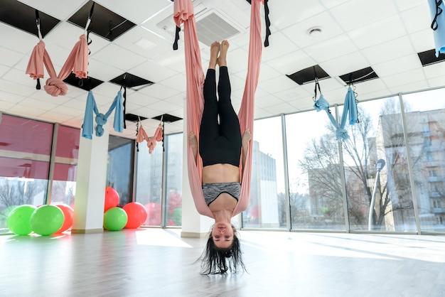 Mujer en el gimnasio haciendo ejercicios de yoga voladores