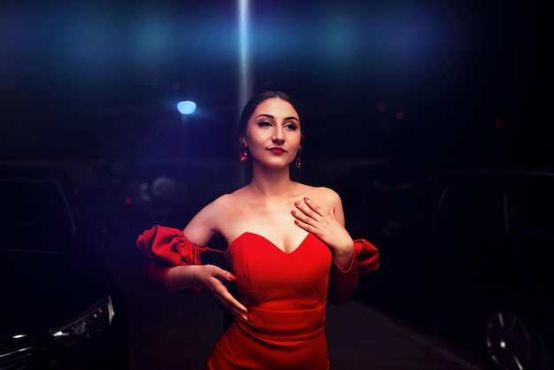 Una mujer glamorosa con un vestido rojo posando en la ciudad.