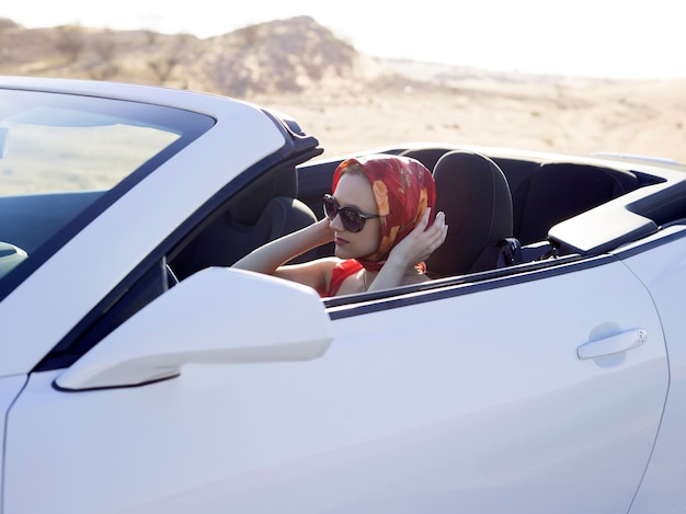 Mujer glamour en coche convertible bufanda drive