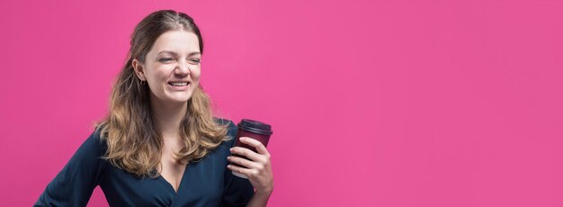 Mujer de glamour con una copa de café sobre un fondo rosa