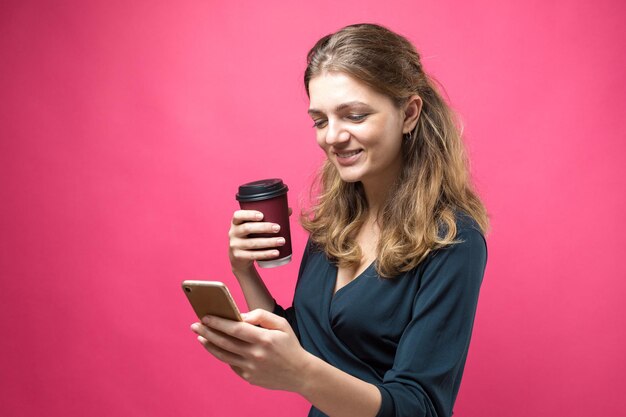 Mujer de glamour con una copa de café sobre un fondo rosa