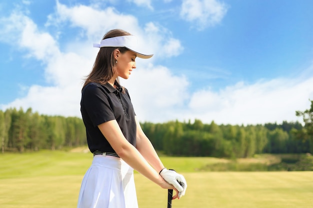 Mujer golfista golpea un tiro de calle hacia la casa club.