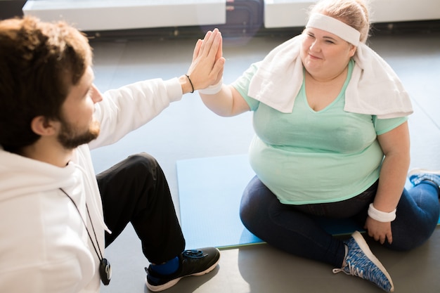 Mujer gorda High Five con entrenador