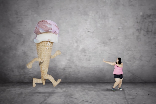 Foto mujer gorda huyendo de un helado