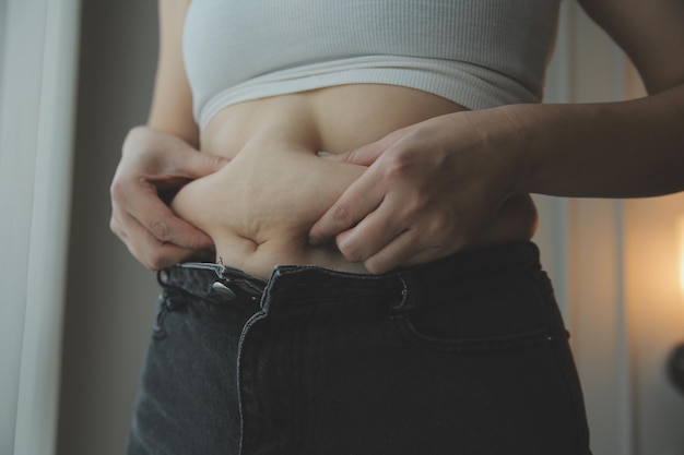 Mujer gorda que mide la mujer gorda vientre gordo gordito panzón deporte recreación cuidado de la salud perder grasa abdominal no hacer ejercicio concepto