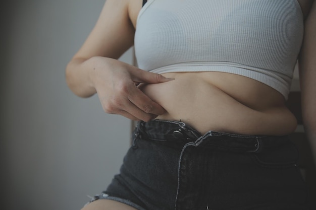 Mujer gorda que mide la mujer gorda vientre gordo gordito panzón deporte recreación cuidado de la salud perder grasa abdominal no hacer ejercicio concepto
